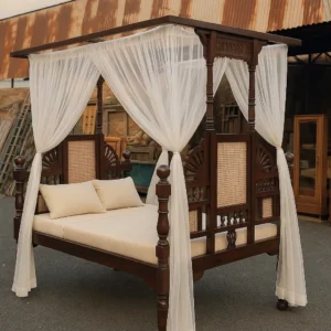 Mahogany four poster 6×6 bed with dark wood frame, carved panels, cane inserts and white sheer canopy drapes in Kenya