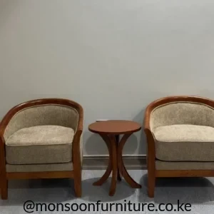 Two beige upholstered wooden armchairs with curved frames and a small round side table between them.