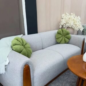 Modern light-grey 3 seater sofa with rounded arms and contrasting wood-toned side accents in a furnished living room