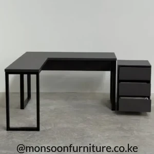 Black L-shaped office desk with open-frame legs and a three-drawer pedestal beside the main worktop.