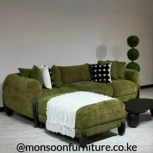 Olive green modular sectional sofa with matching ottoman, broad cushions and black feet in a modern living room