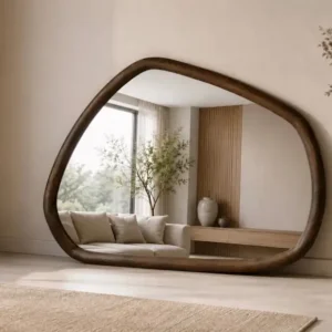 Organic full length floor mirror with irregular rounded shape and dark brown frame in a neutral living room
