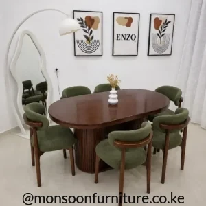 Oval dark brown dining table with ribbed pedestal base and six green upholstered dining chairs.