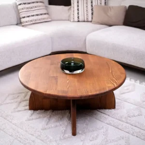 Round mahogany wood centre table with warm brown top and sculptural curved base in a modern living room