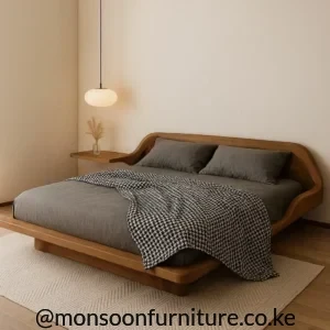 Rounded brown wood-grain bed frame with curved headboard side, low frame and grey bedding.