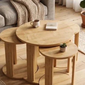 Three-piece round nesting table set in a light natural wood-look finish arranged in a living room