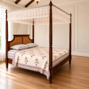 Walnut four poster bed with tall carved posts, woven headboard and white canopy fabric in a bright bedroom