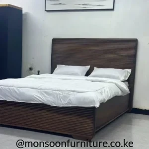 5×6 dark brown walnut-toned wooden bed with horizontal ribbed headboard and matching footboard in a bedroom