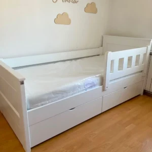 White 90×200 cm kids bed with side rail and under-bed storage in a child’s bedroom