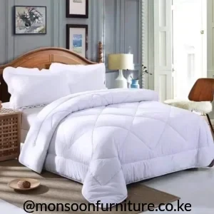 White duvet with large stitched quilted panels and a finished bound edge arranged across a bed.