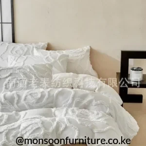 White duvet cover set with raised floral texture and two matching textured pillowcases on a bed