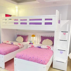 White triple sleeper bed with upper guard rails, two lower beds and storage staircase in a shared bedroom