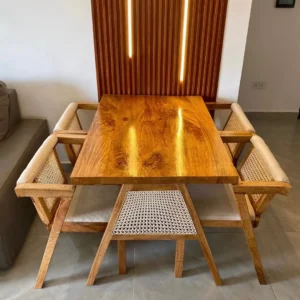 Wooden rectangular dining table with warm brown top, upholstered chairs and woven cane-style backs in a dining room