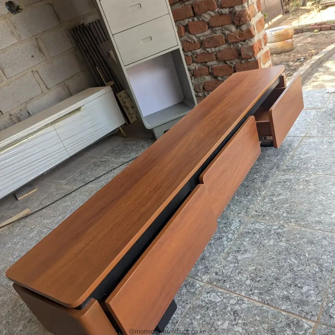 Wooden TV cabinet with drawers in warm brown wood-look finish and dark contrasting storage sections