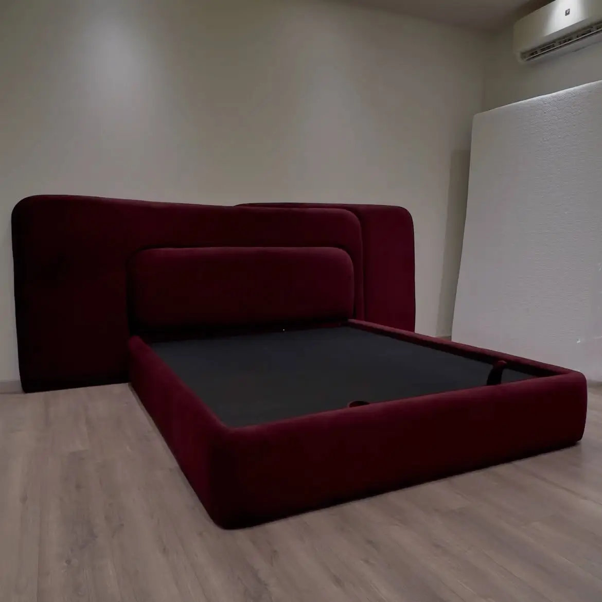 5×6 burgundy upholstered bed with under-bed storage and wide layered headboard