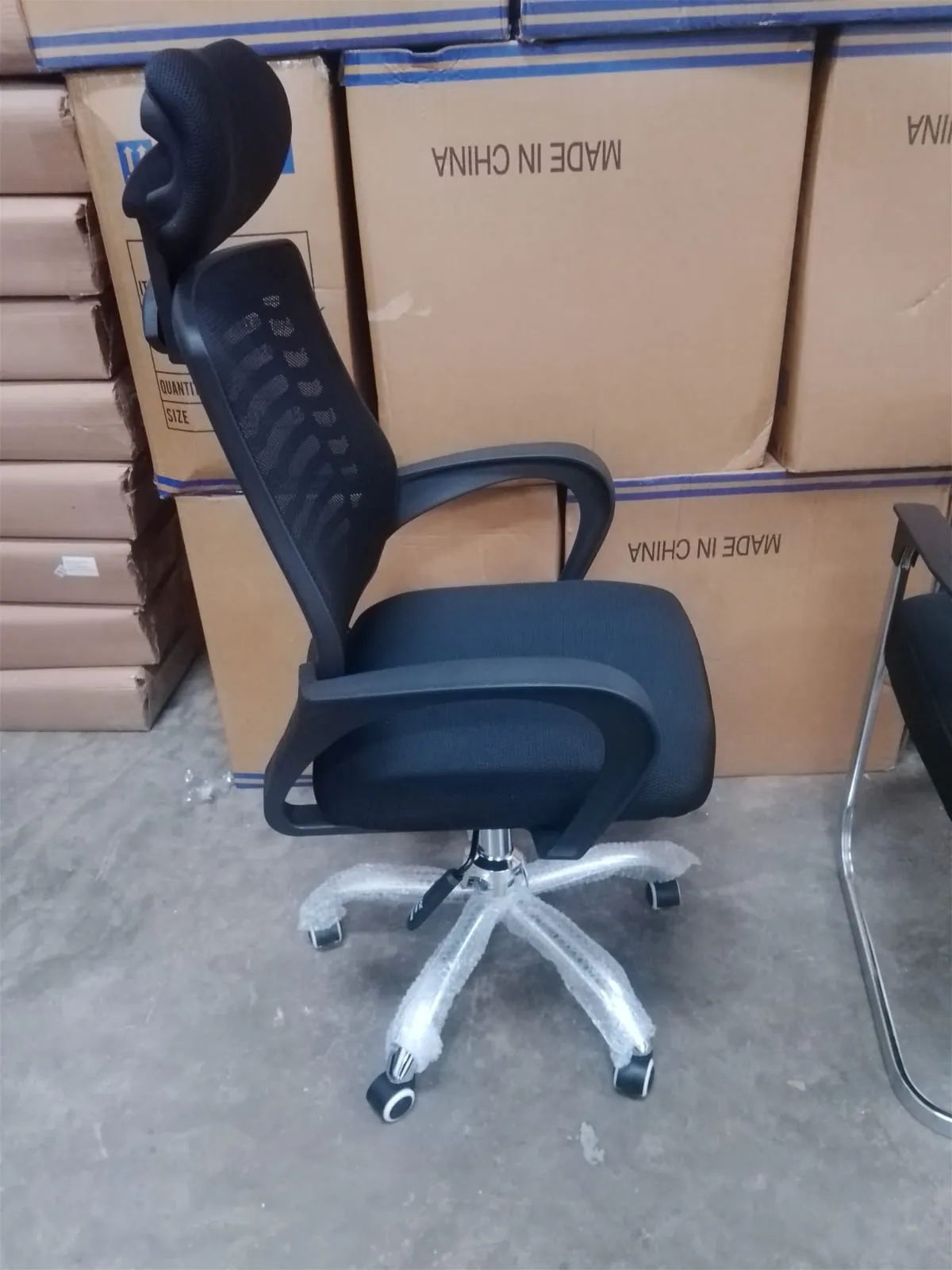Black high-back mesh office chair with headrest and armrests
