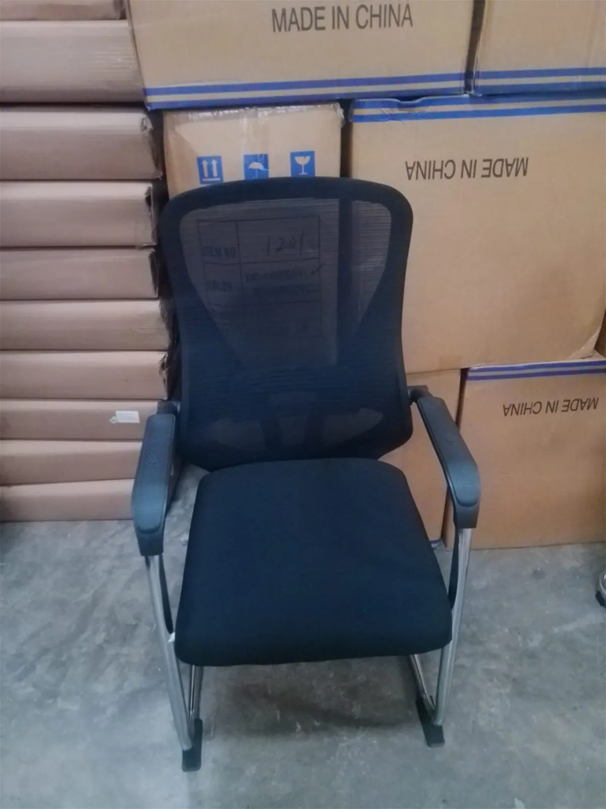 Black mesh visitor office chair with padded seat and fixed armrests