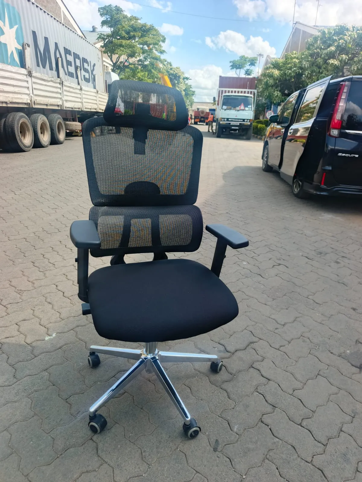 Black high-back mesh office chair with headrest and lumbar support