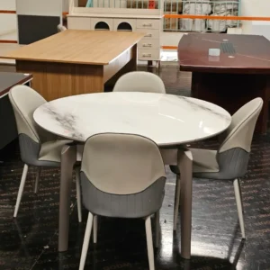 Round white dining table with glossy marble-look top and four upholstered chairs
