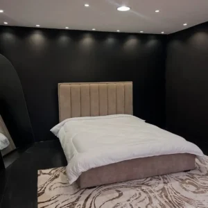 Beige 5×6 upholstered bed with tall vertical-panel headboard and matching upholstered base