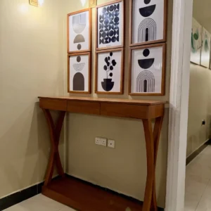 Brown natural wood console table with three drawers and curved supports