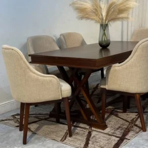 Brown dining table with geometric cross base and light upholstered chairs
