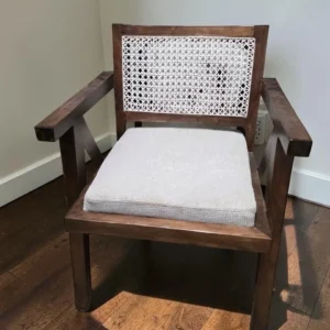 Dark brown wooden accent chair with light cushioned seat and geometric woven back