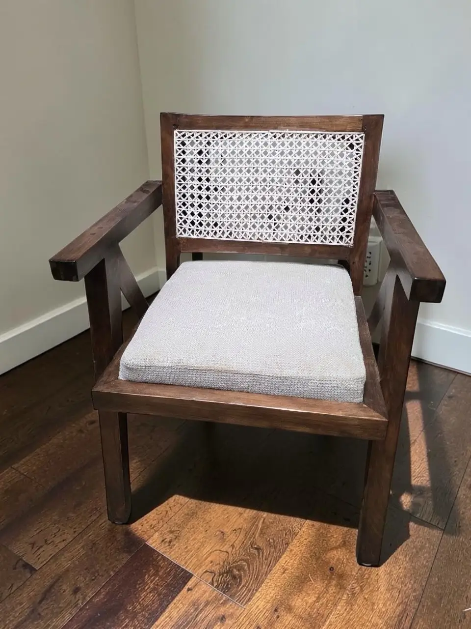 Dark brown wooden accent chair with light cushioned seat and geometric woven back