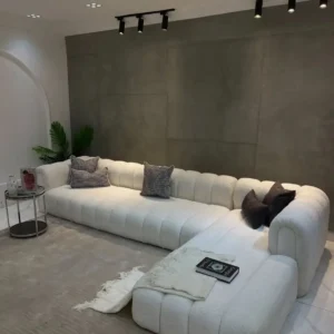 Cream chaise sectional sofa with scalloped segmented back and rounded arms