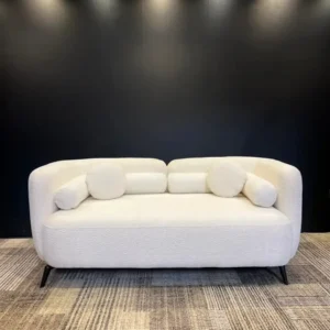 Cream textured 3 seater sofa with rounded arms, loose cushions and dark raised legs