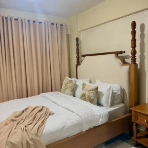 5x6 full poster bed with light padded headboard and tall brown posts