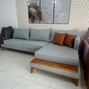 Light grey chaise sofa with warm wood-tone side platform and lower trim