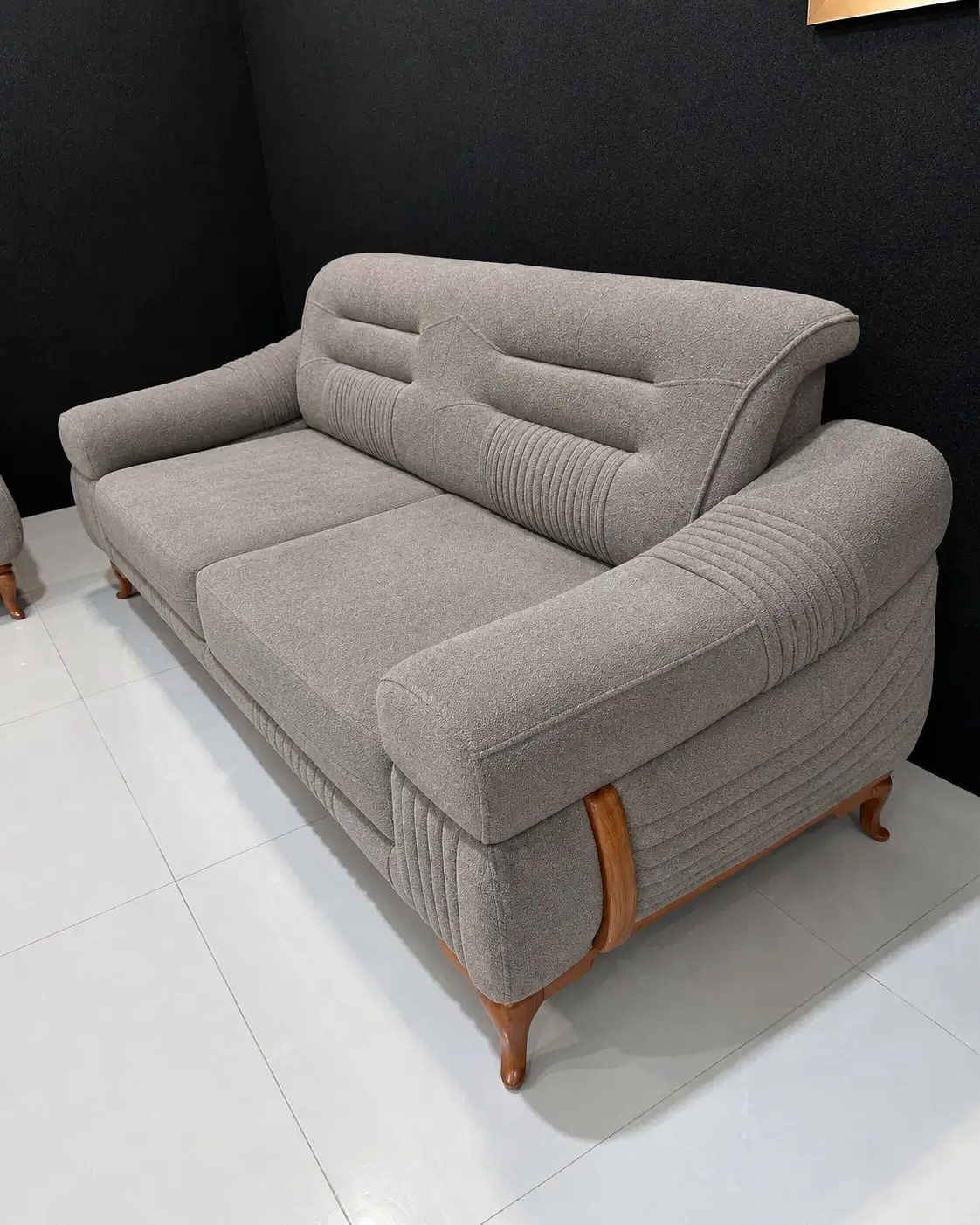 Light grey 5 seater sofa with ribbed arms and wood-tone accents in Kenya
