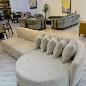 Light neutral curved chaise sofa with rounded lounge end and loose cushions