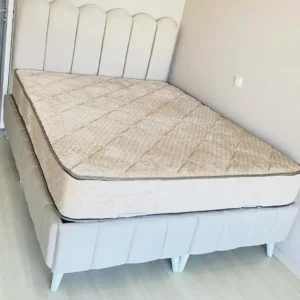 Light neutral upholstered bed with rounded vertical-panel headboard