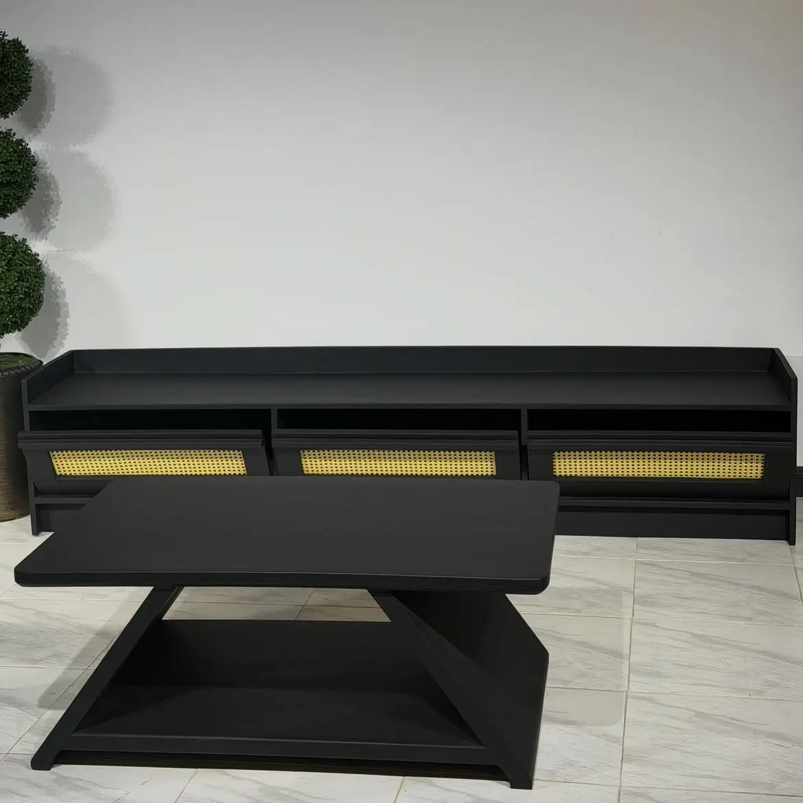 Black TV cabinet with three light woven-style front panels and matching geometric coffee table