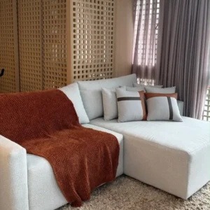 Off-white chaise sofa with wide upholstered arms and loose back cushions