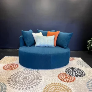 Royal blue curved sofa in ribbed fabric with blue, orange, white and patterned cushions