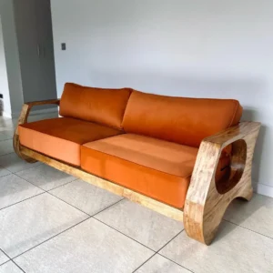 Terracotta upholstered sofa with curved exposed wood frame and oval arm openings in a tiled living room