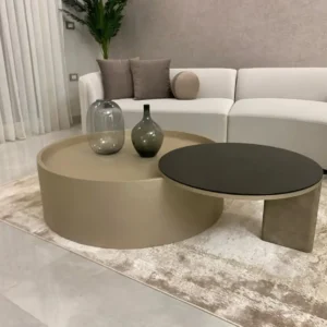 Two-tone round coffee table with overlapping taupe and dark charcoal surfaces