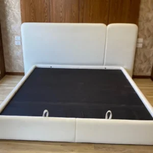 White padded bed and couch combination with wide asymmetric headboard