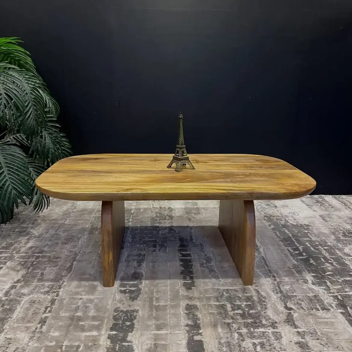 Wooden pedestal dining table with rounded rectangular top and twin panel supports in a warm natural finish