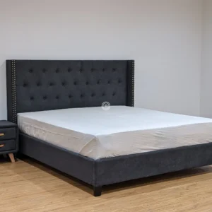 Monsoon Alderhurst 6×6 charcoal grey upholstered bed with button-tufted headboard, gold-tone studs and low upholstered base.
