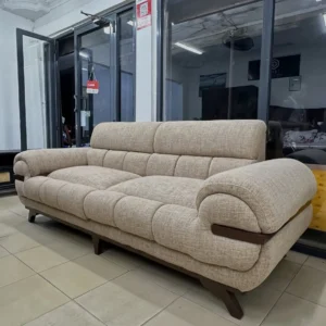 Beige sofa with horizontally segmented cushioned seats, rounded arms and dark wood-tone detailing.