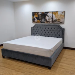 Monsoon Bellbrook 6×6 dark grey fabric upholstered bed with diamond button-tufted headboard, curved winged top and metallic stud trim.