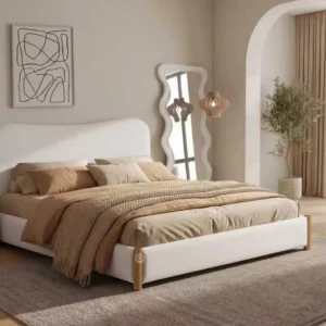Monsoon Dalemere 6×6 off-white fabric upholstered bed with asymmetrically curved headboard, matching low footboard and wood-look corner accents.