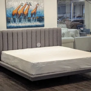 Monsoon Glenleigh 6×6 grey fabric upholstered bed with a tall vertical-channel headboard, slim matching frame and short dark legs.