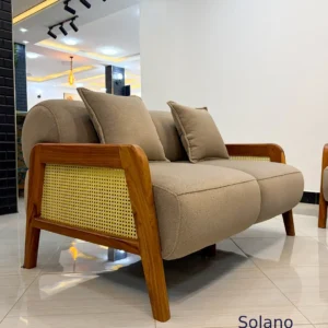 Beige Solano sofa with warm wooden arm frames, woven side panels and curved upholstered back